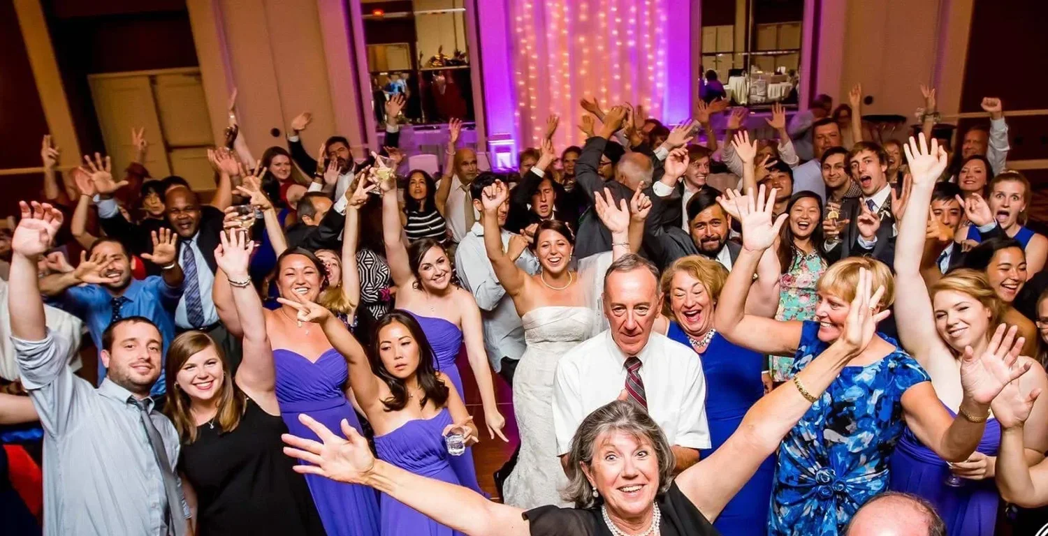 Guests with hands in the air on a packed dance floor